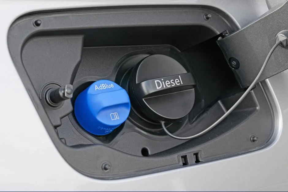 Bidon d'AdBlue et réservoir ouvert dans un moteur diesel, vue rapprochée en atelier